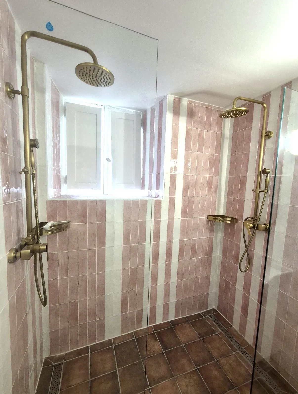 Douche à l'italienne en zellige rose posé en bandes verticales, robinetterie laiton