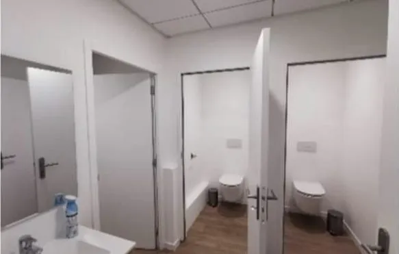 Sanitaires d'entreprise livrés : cloisons, deux WC suspendus, lave-mains et miroir